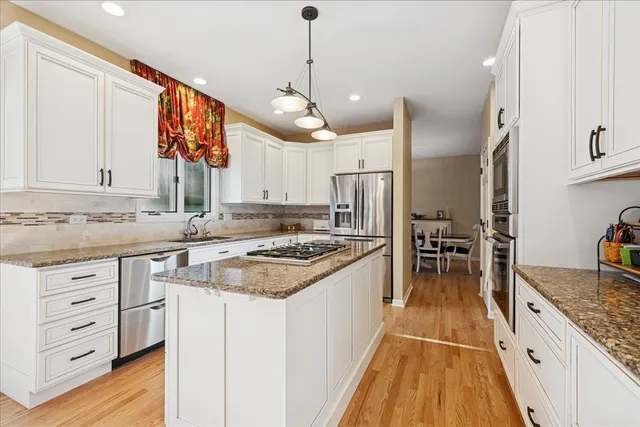 a kitchen with granite countertop a sink stove and refrigerator