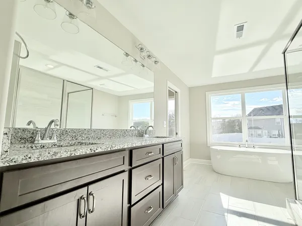 a bathroom with a granite countertop sink mirror and bathtub