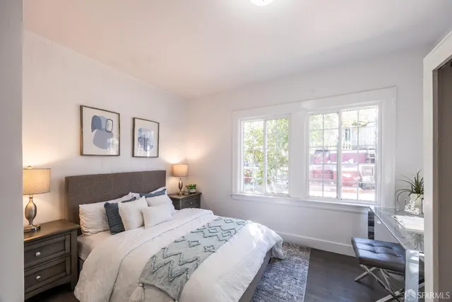 a bedroom with a bed and a window with a chair