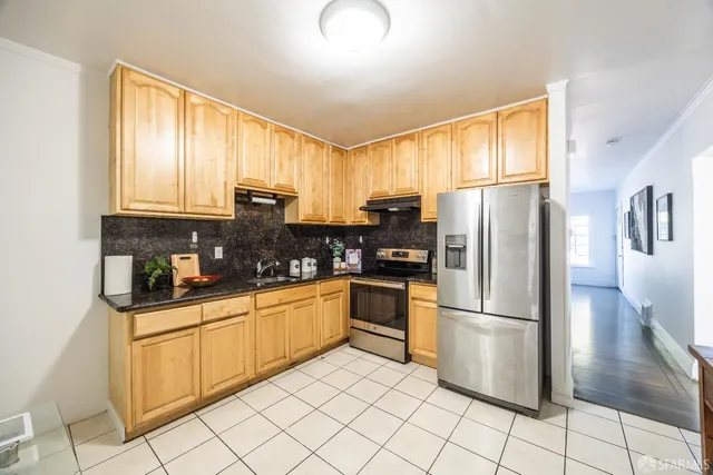 a kitchen with a refrigerator a microwave a sink and cabinets