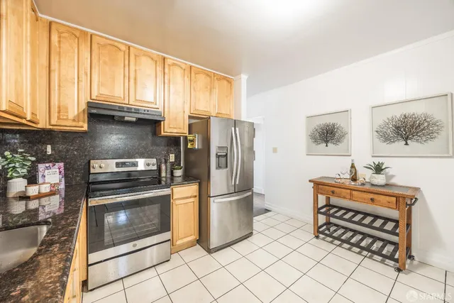 a kitchen with stainless steel appliances a stove a refrigerator and a microwave