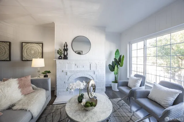 a living room with furniture a fireplace and potted plants