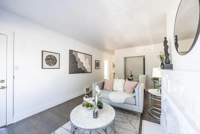 a living room with furniture a mirror and a table