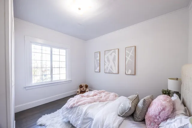 a bed sitting in a bedroom next to a window