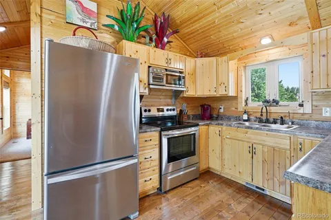 a kitchen with stainless steel appliances granite countertop a sink stove and cabinets