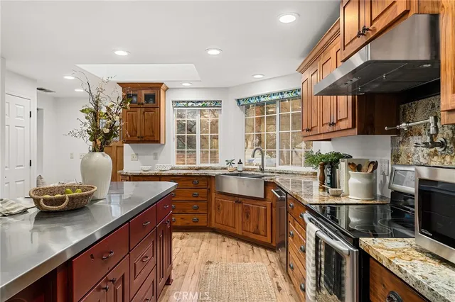 a kitchen with stainless steel appliances granite countertop a stove a sink dishwasher and a refrigerator