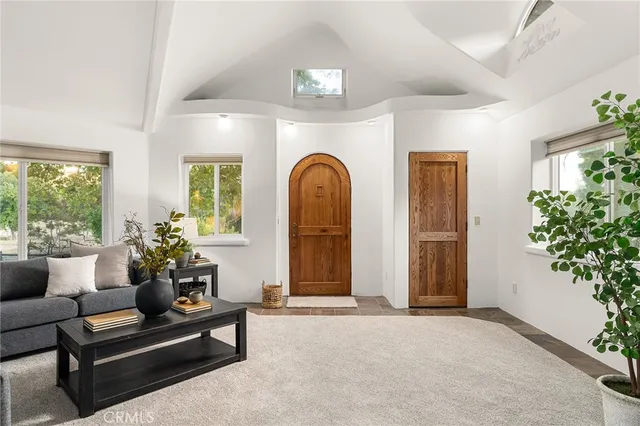 a living room with furniture and flower plants