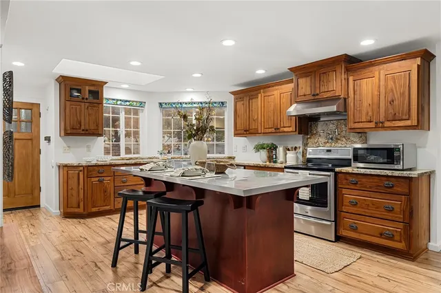 a kitchen with stainless steel appliances granite countertop a sink stove and cabinets