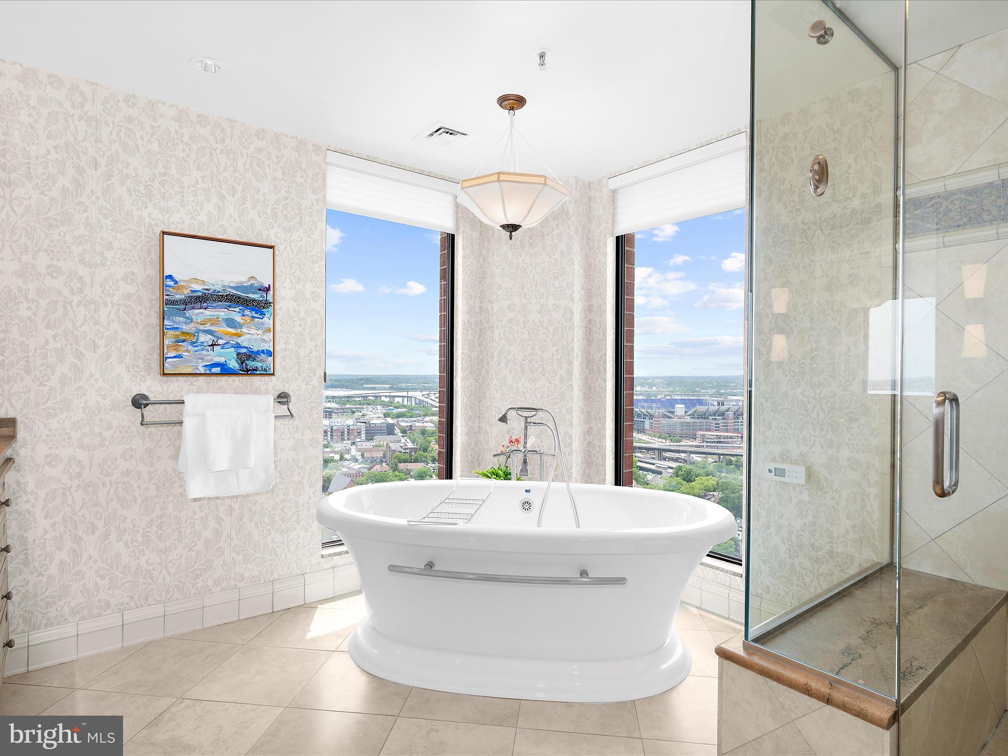 10 East Lee Street, Unit 2405 Baltimore, MD 21202 - Photo 15 of 50 a view of a bathroom with a tub shower and mirror
