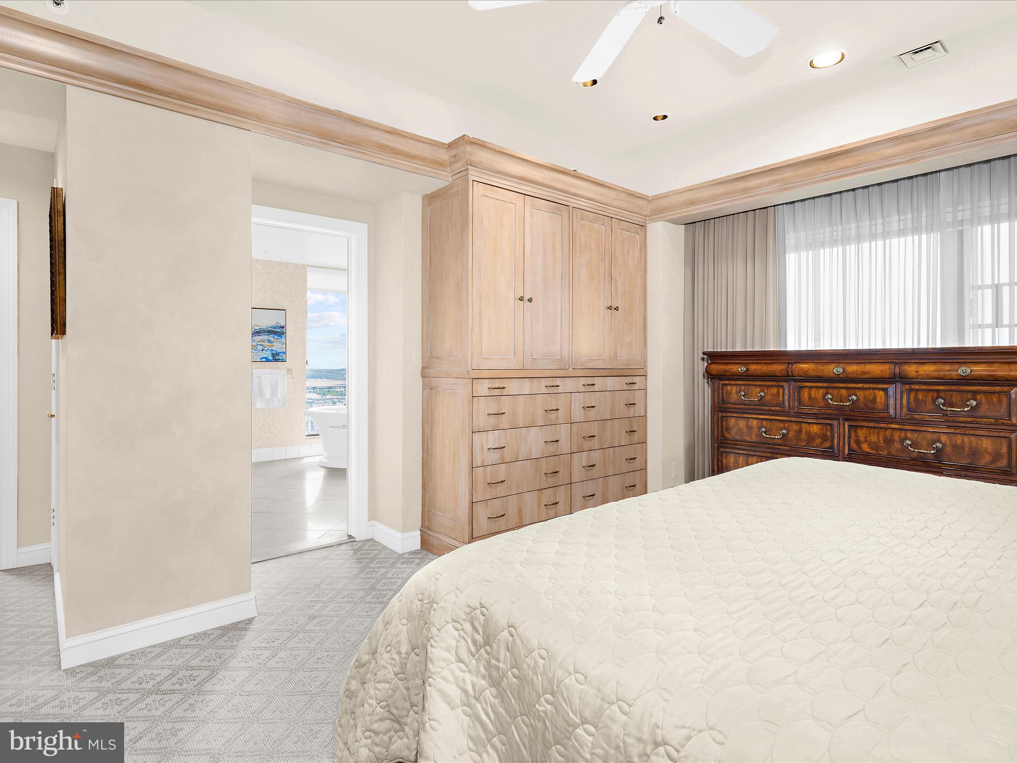 10 East Lee Street, Unit 2405 Baltimore, MD 21202 - Photo 20 of 50 a spacious bedroom with a large bed and a dresser