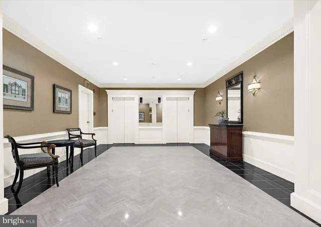 a view of a hallway with furniture and a kitchen