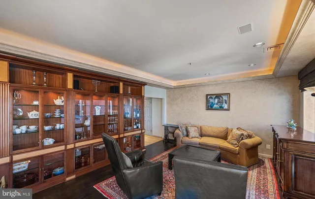 a living room with furniture a bookshelf and a window