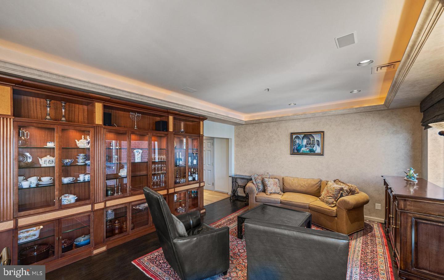 10 East Lee Street, Unit 2405 Baltimore, MD 21202 - Photo 5 of 50 a living room with furniture a bookshelf and a window