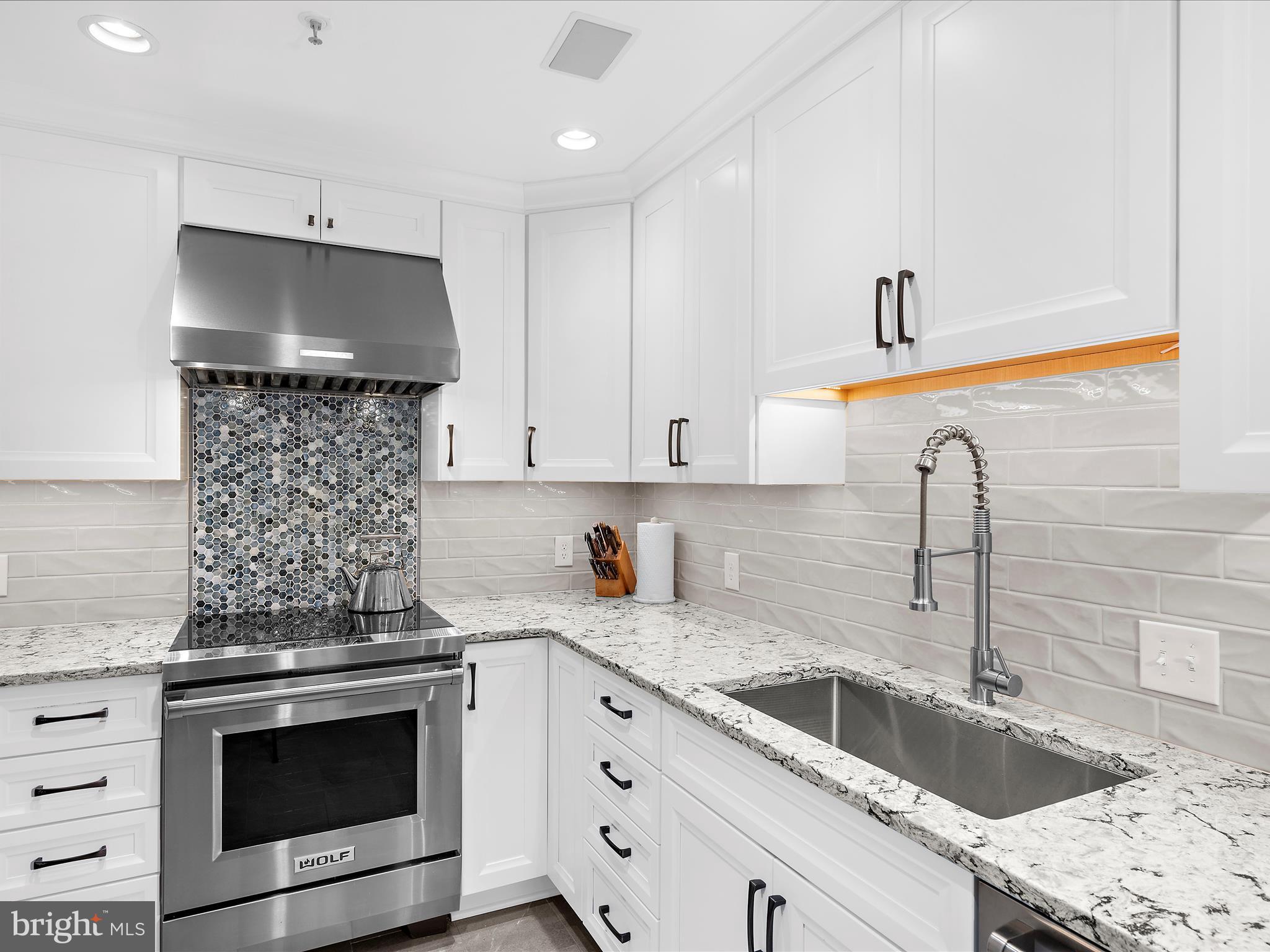 10 East Lee Street, Unit 2405 Baltimore, MD 21202 - Photo 7 of 50 a kitchen with granite countertop a sink stove and cabinets