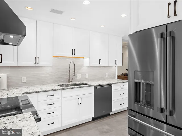 a kitchen with a sink stainless steel appliances and cabinets