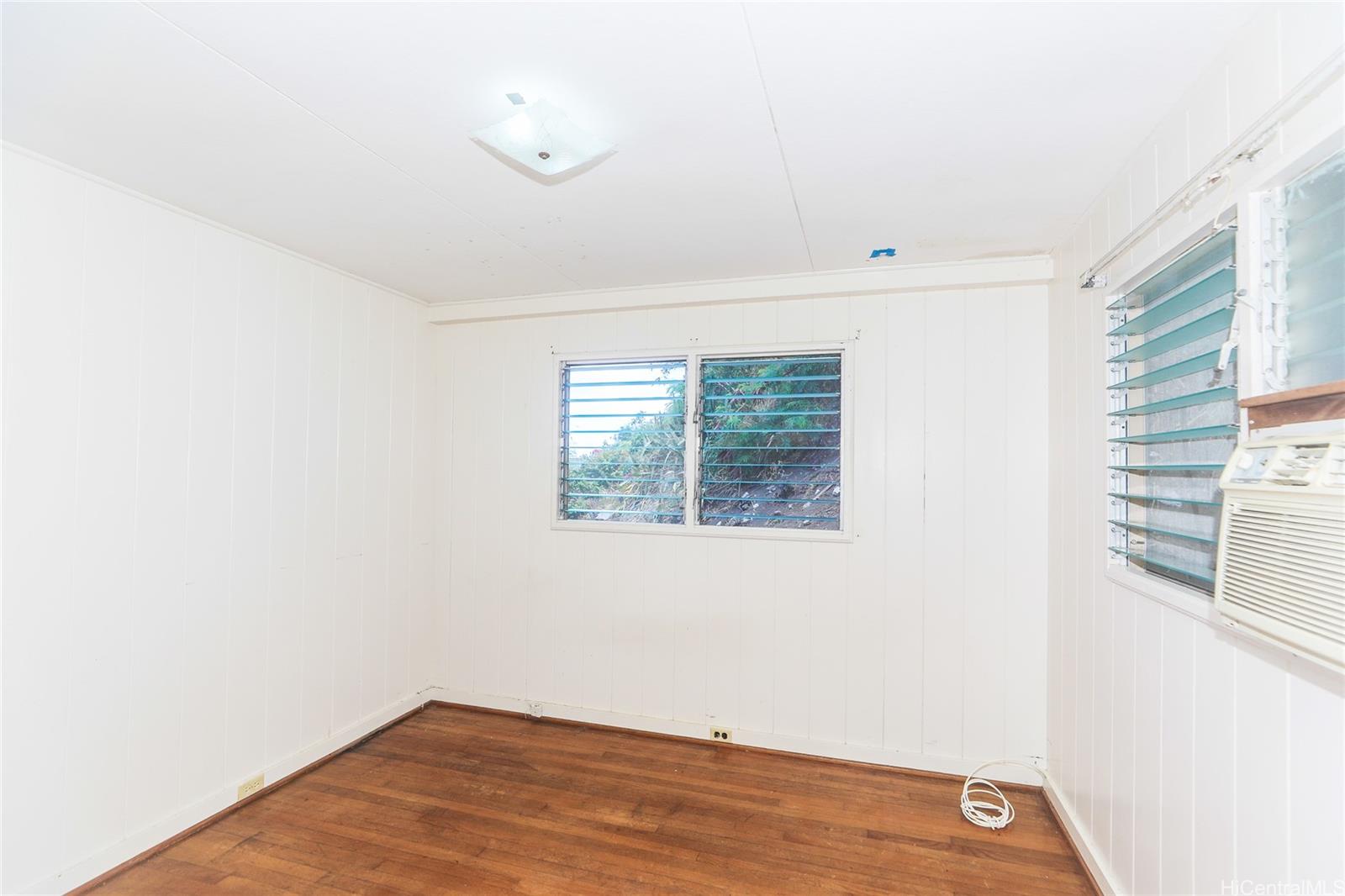 1952 Nehoa Place Honolulu, HI 96822 - Photo 13 of 25 a view of an empty room with wooden floor and a window