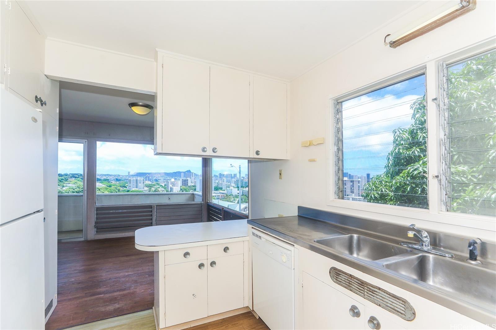 1952 Nehoa Place Honolulu, HI 96822 - Photo 9 of 25 a kitchen with a sink window and cabinets