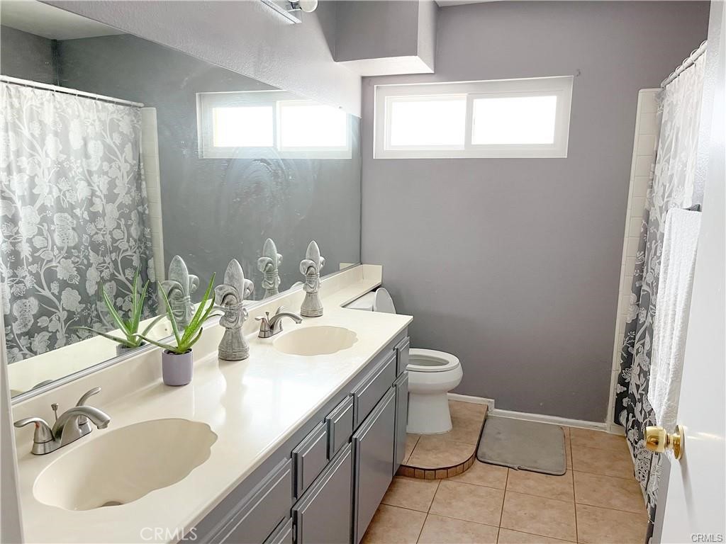 15980 Filbert Street Sylmar, CA 91342 - Photo 13 of 17 a bathroom with a toilet sink and mirror