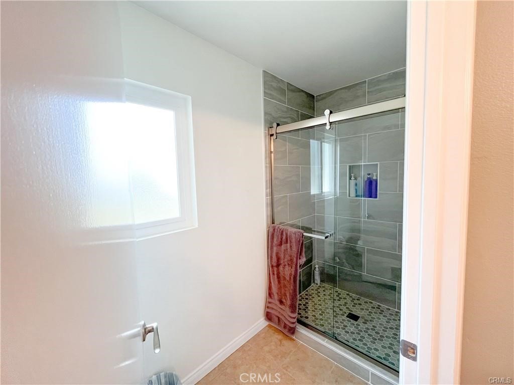 15980 Filbert Street Sylmar, CA 91342 - Photo 9 of 17 a bathroom with a glass shower door