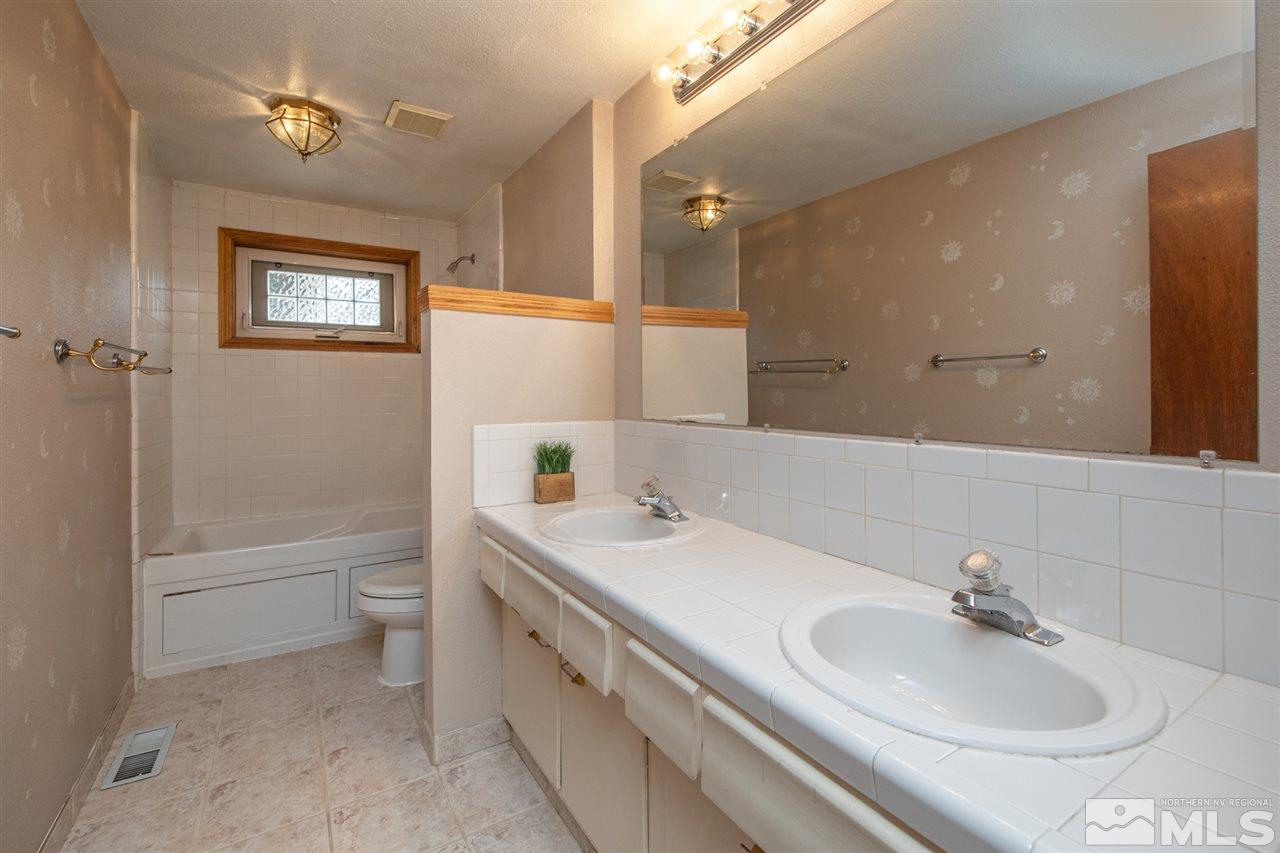 4095 Warren Way Reno, NV 89509 - Photo 15 of 17 a bathroom with a sink a toilet and shower