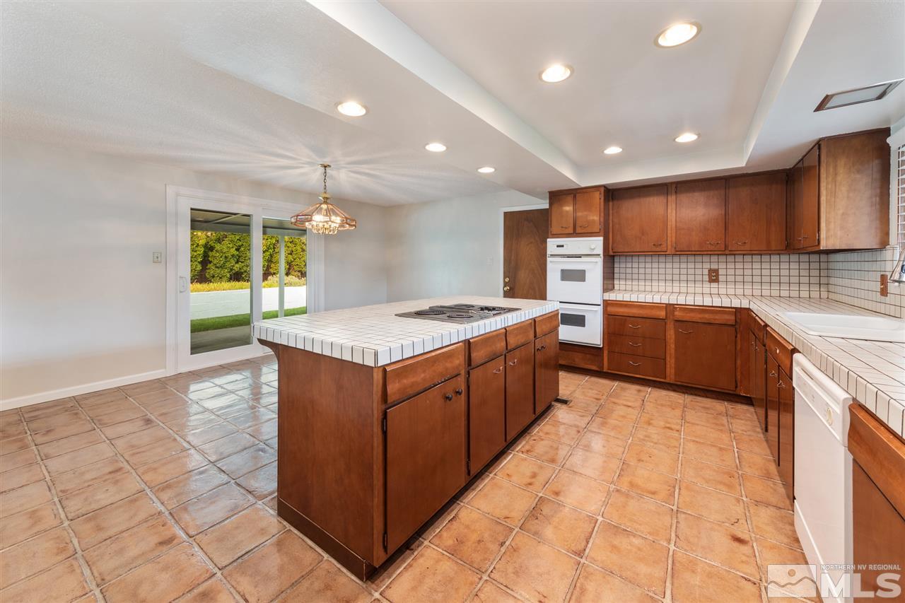 4095 Warren Way Reno, NV 89509 - Photo 4 of 17 a kitchen with stainless steel appliances granite countertop a sink counter space cabinets and a large window