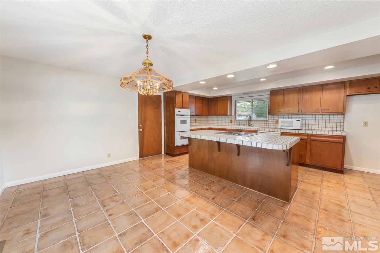 4095 Warren Way Reno, NV 89509 - Photo 5 of 17 a large kitchen with stainless steel appliances granite countertop a stove a sink a refrigerator and a granite counter top