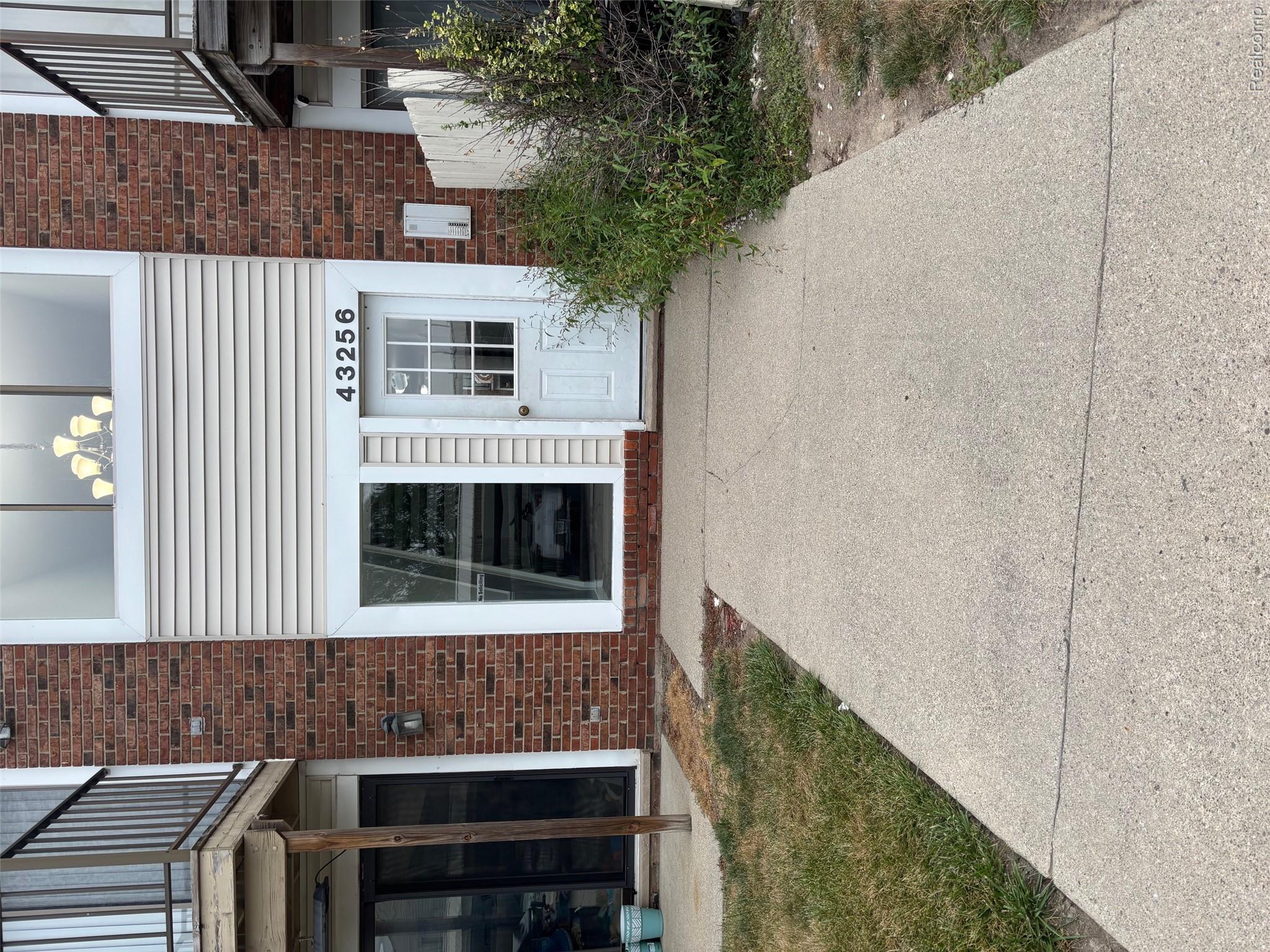 Red brick and siding exterior with a prominent entrance door