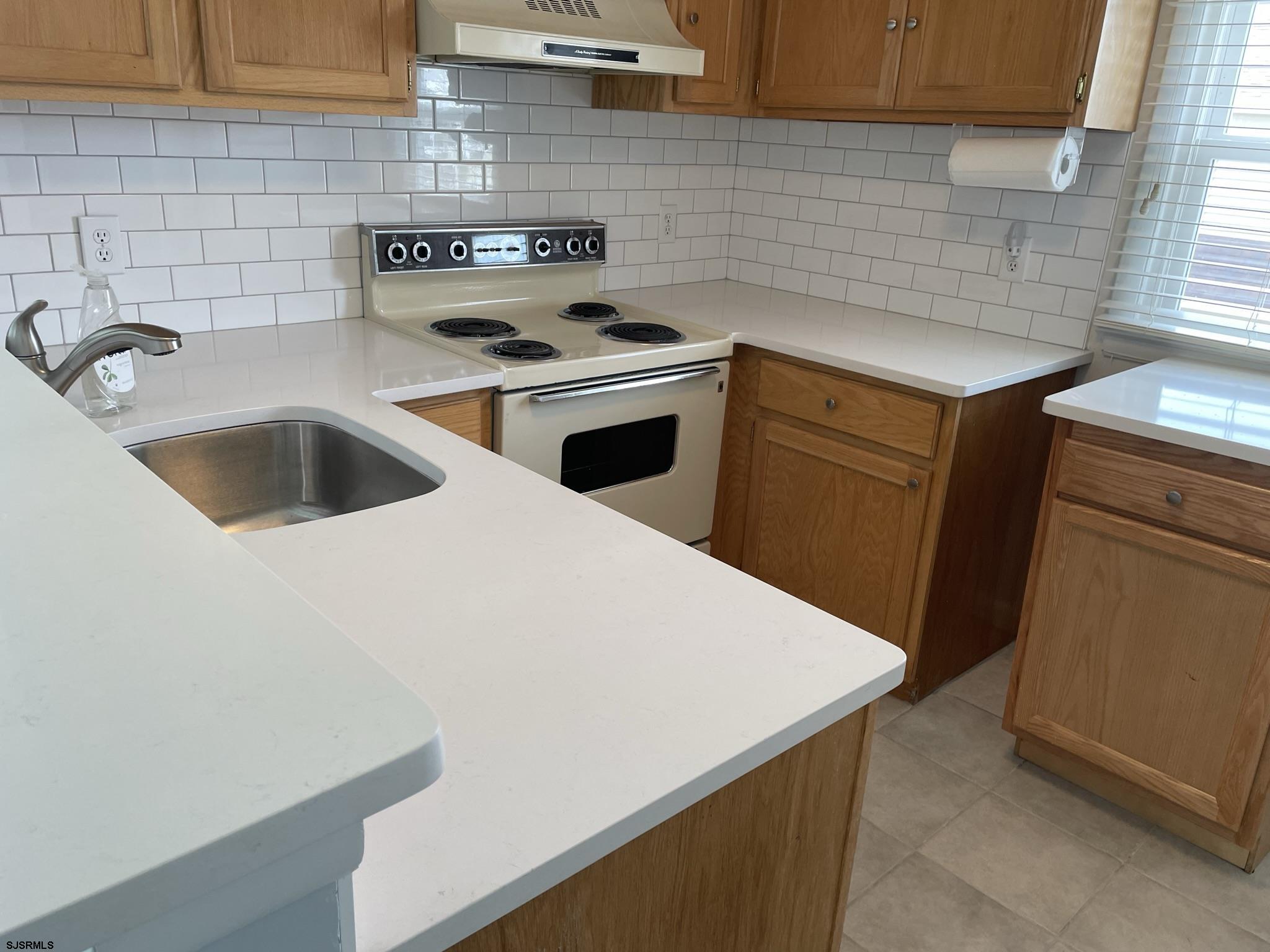 61 Simpson Road, Unit 2 Ocean City, NJ 08226 - Photo 13 of 16 a kitchen with a sink cabinets and a wooden floor