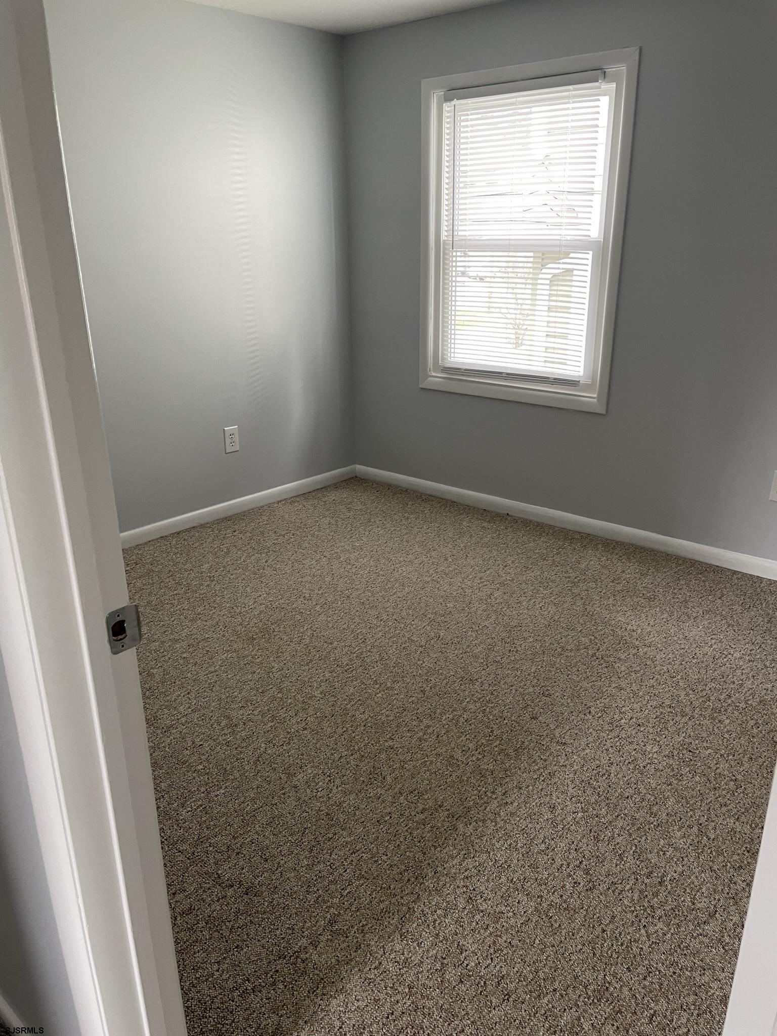 61 Simpson Road, Unit 2 Ocean City, NJ 08226 - Photo 4 of 16 an empty room with windows