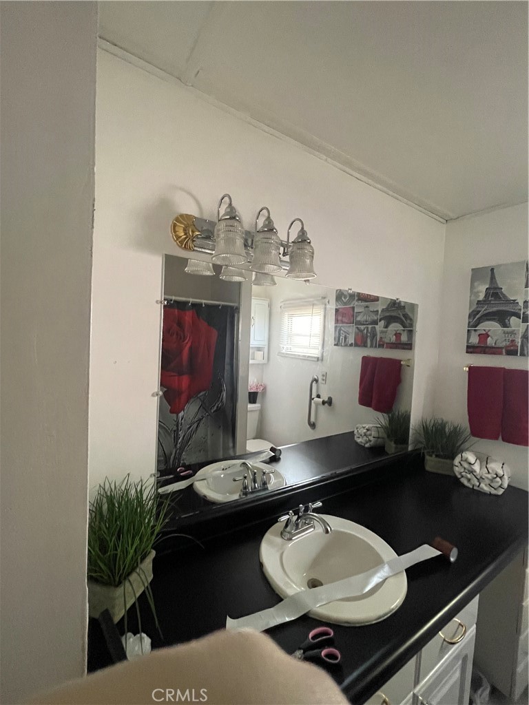 69510 Parkside Drive Desert Hot Springs, CA 92241 - Photo 4 of 5 a bathroom with a sink and a mirror with toilet