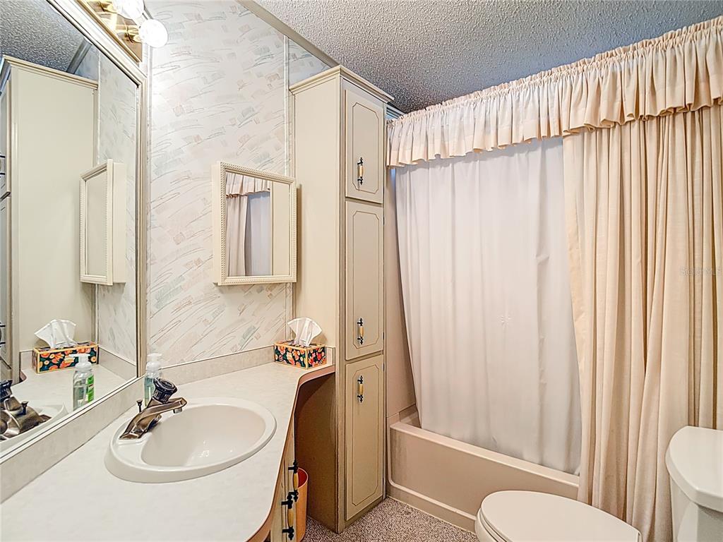 14761 Rialto Avenue Brooksville, FL 34613 - Photo 14 of 23 a bathroom with a sink a toilet and shower curtain