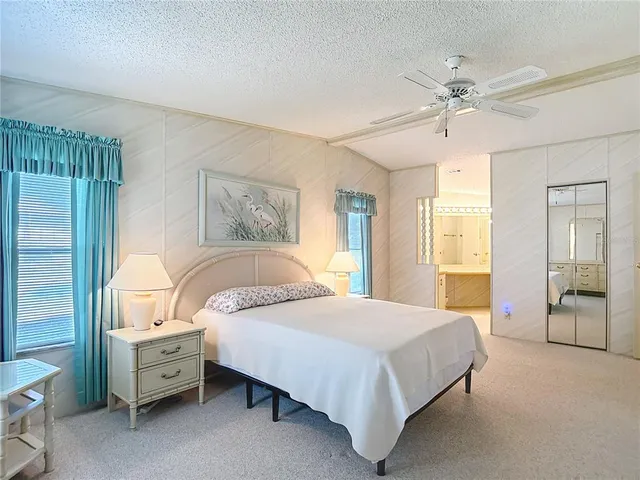 a spacious bedroom with a bed and a chandelier