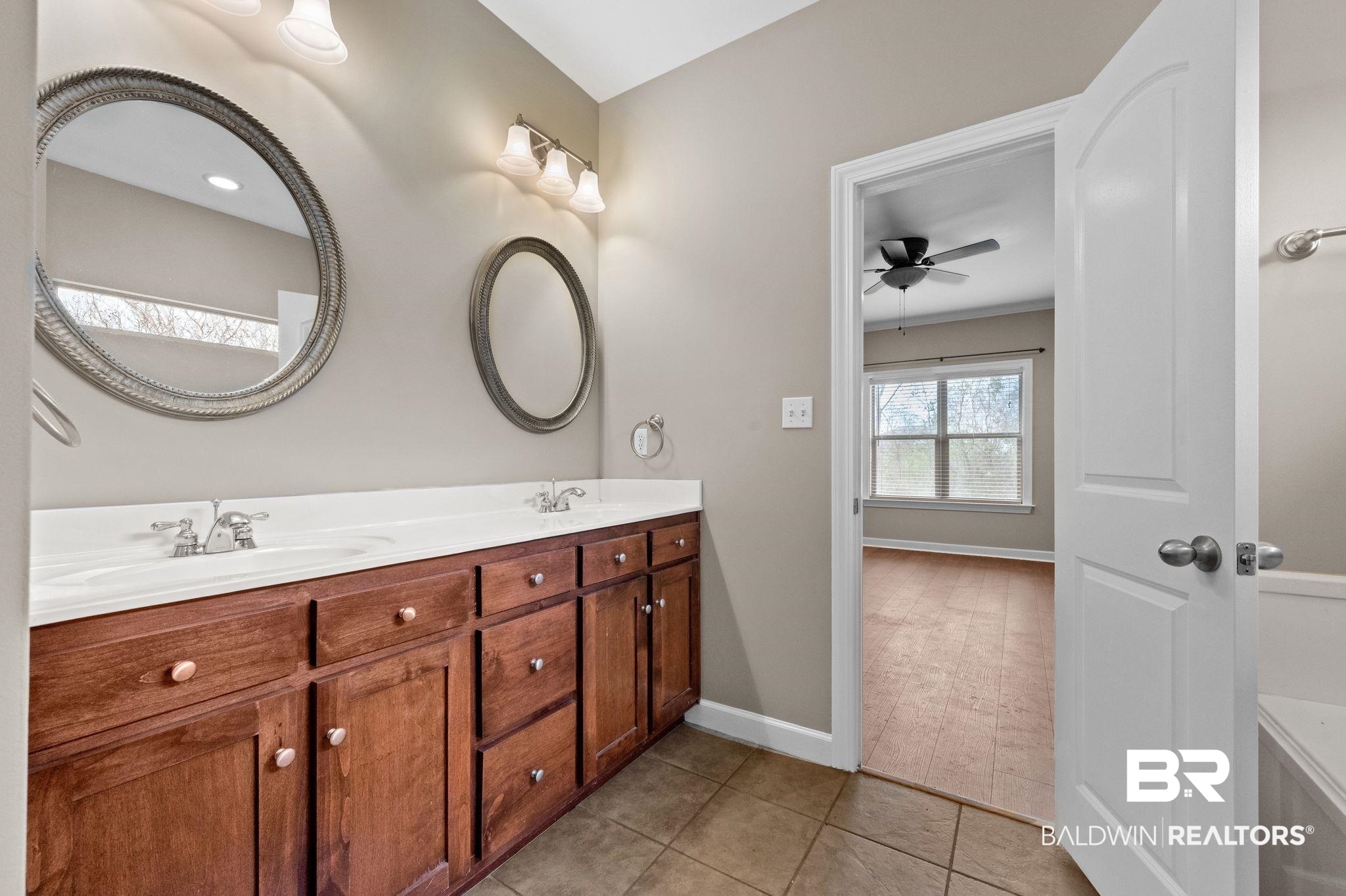 9381 Sable Court Daphne, AL 36526 - Photo 22 of 42 Bathroom featuring double vanity, ceiling fan, a sink, tile patterned flooring, and baseboards