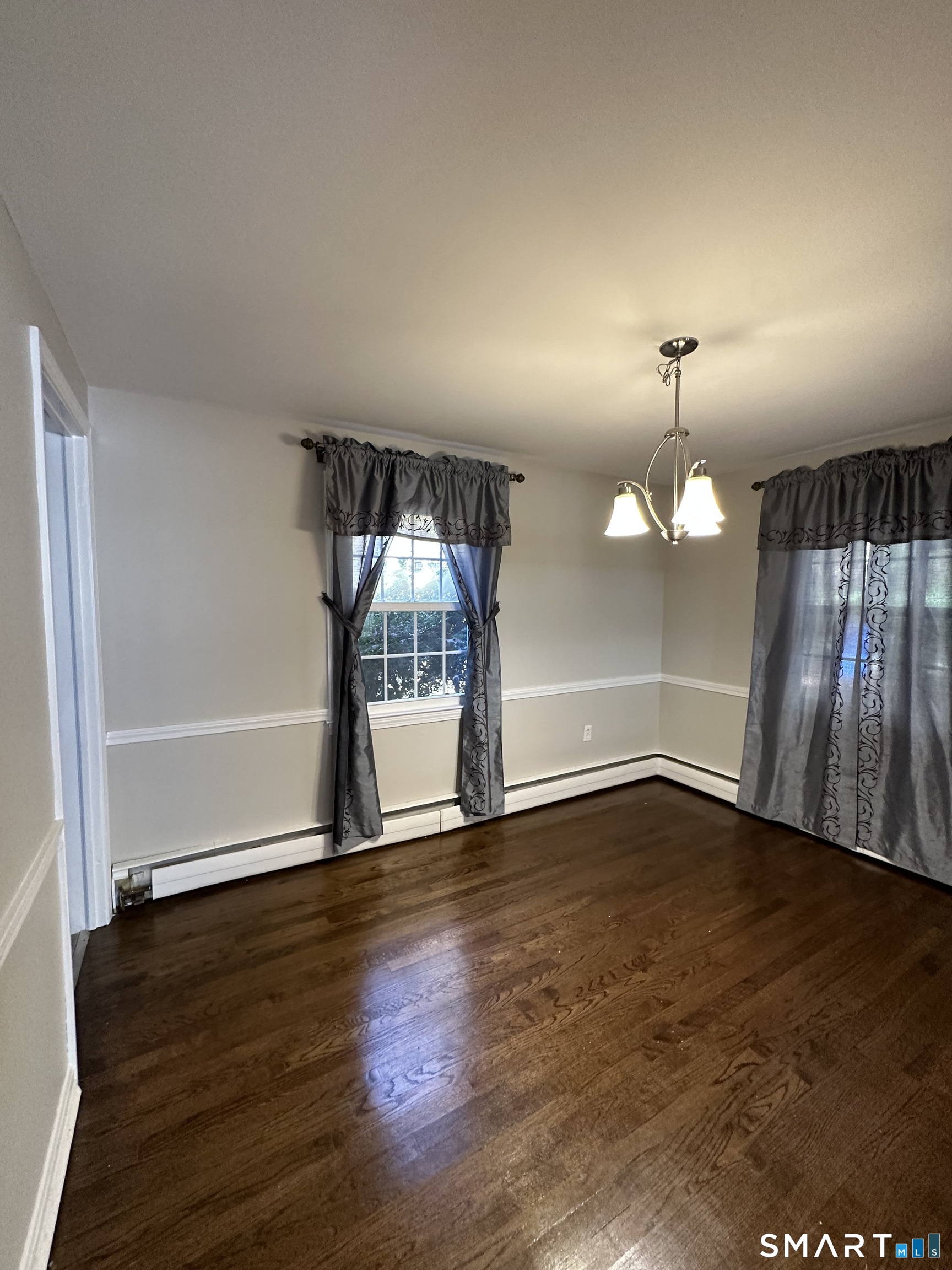 26 South Glenwoods Road Ledyard, CT 06335 - Photo 9 of 12 an empty room with wooden floor mirror and windows
