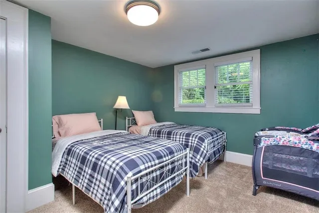 a bedroom with two beds and a chair