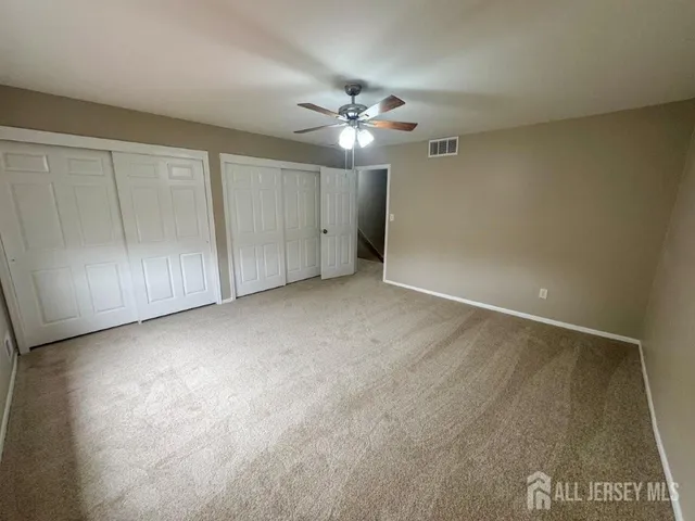 an empty room with a ceiling fan and a window