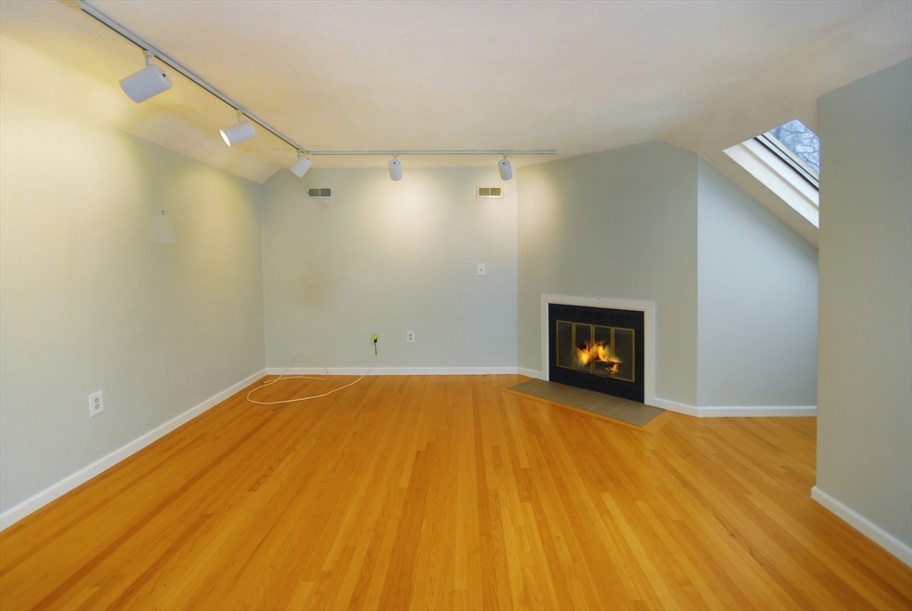 12 Oak Ridge Drive, Unit 4 Maynard, MA 01754 - Photo 19 of 36 a view of empty room with wooden floor and fireplace