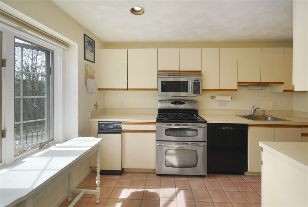 12 Oak Ridge Drive, Unit 4 Maynard, MA 01754 - Photo 4 of 36 a kitchen with a stove a sink and a microwave