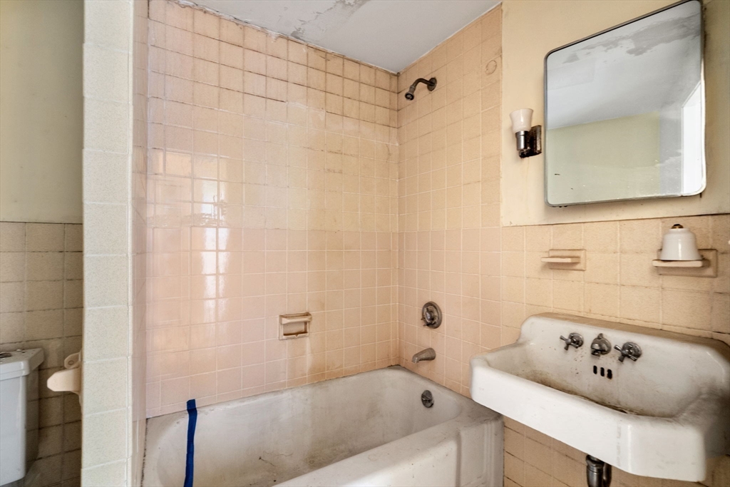 1495 Beacon Street, Unit 3 Brookline, MA 02446 - Photo 11 of 27 a bathroom with a bathtub a sink and a mirror