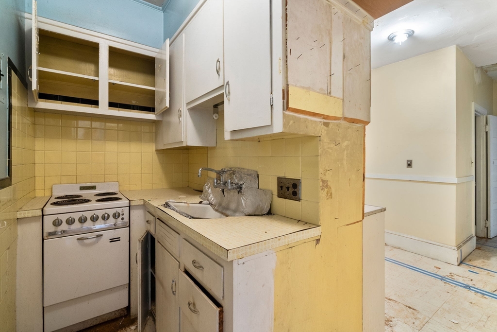1495 Beacon Street, Unit 3 Brookline, MA 02446 - Photo 13 of 27 a kitchen with a stove and a cabinets