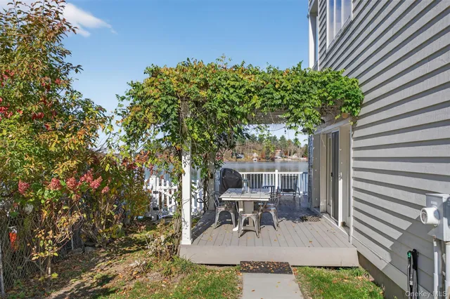 a view of a patio with table and chairs and potted plants with wooden floor and fence