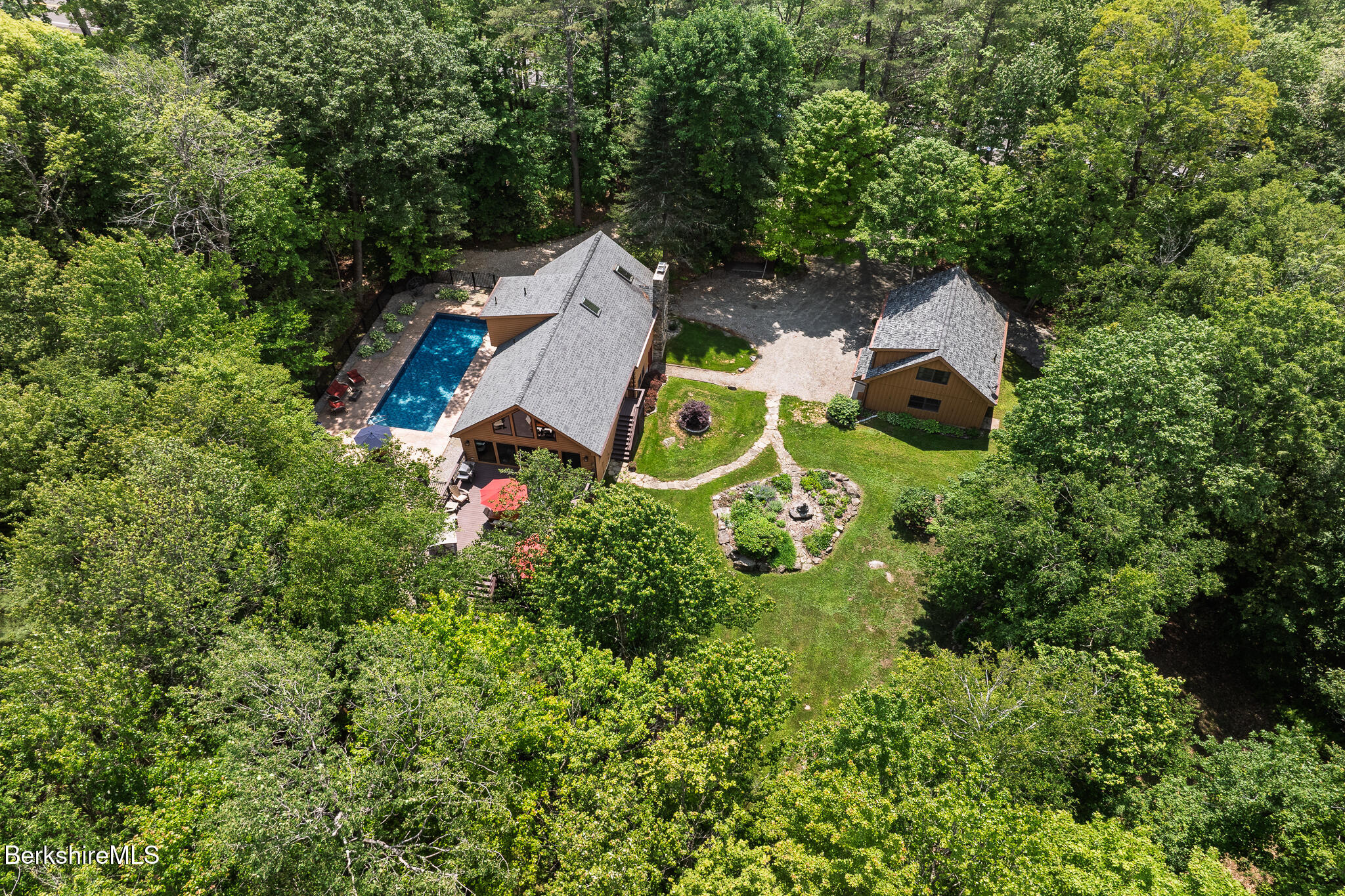 an aerial view of a house with a garden and trees