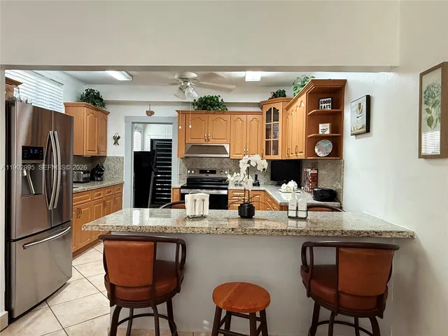 a kitchen with stainless steel appliances granite countertop a sink refrigerator and cabinets