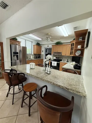 a kitchen with stainless steel appliances granite countertop a sink a stove and a refrigerator