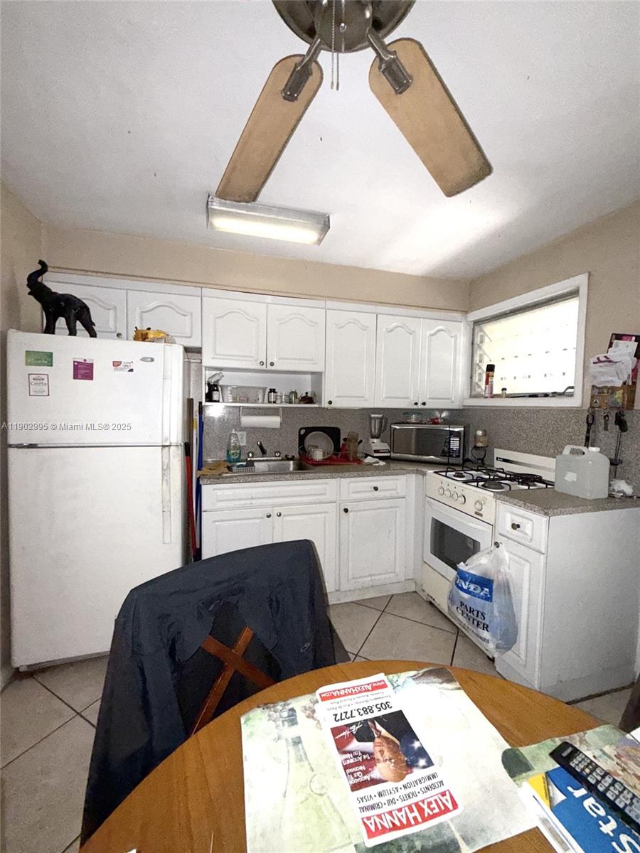 1835 Southwest 10th Street Miami, FL 33135 - Photo 45 of 50 a kitchen with a refrigerator a stove a sink and white cabinets