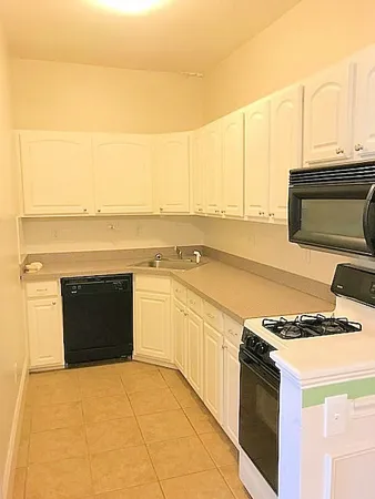 a kitchen with stainless steel appliances granite countertop a stove and a white cabinets