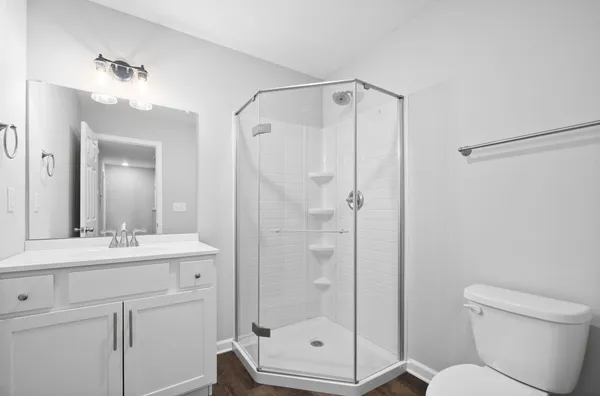 a bathroom with a shower a mirror a toilet and a sink