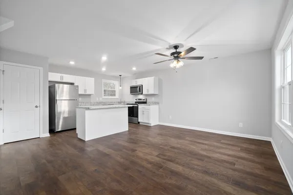 a view of kitchen with granite countertop cabinets and refrigerator