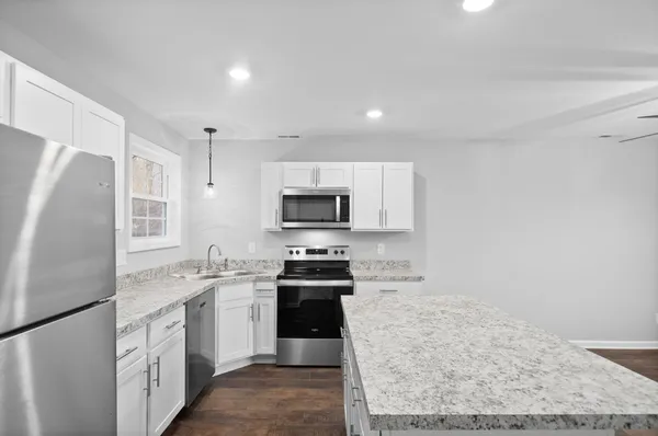 a kitchen with a sink stainless steel appliances and white cabinets