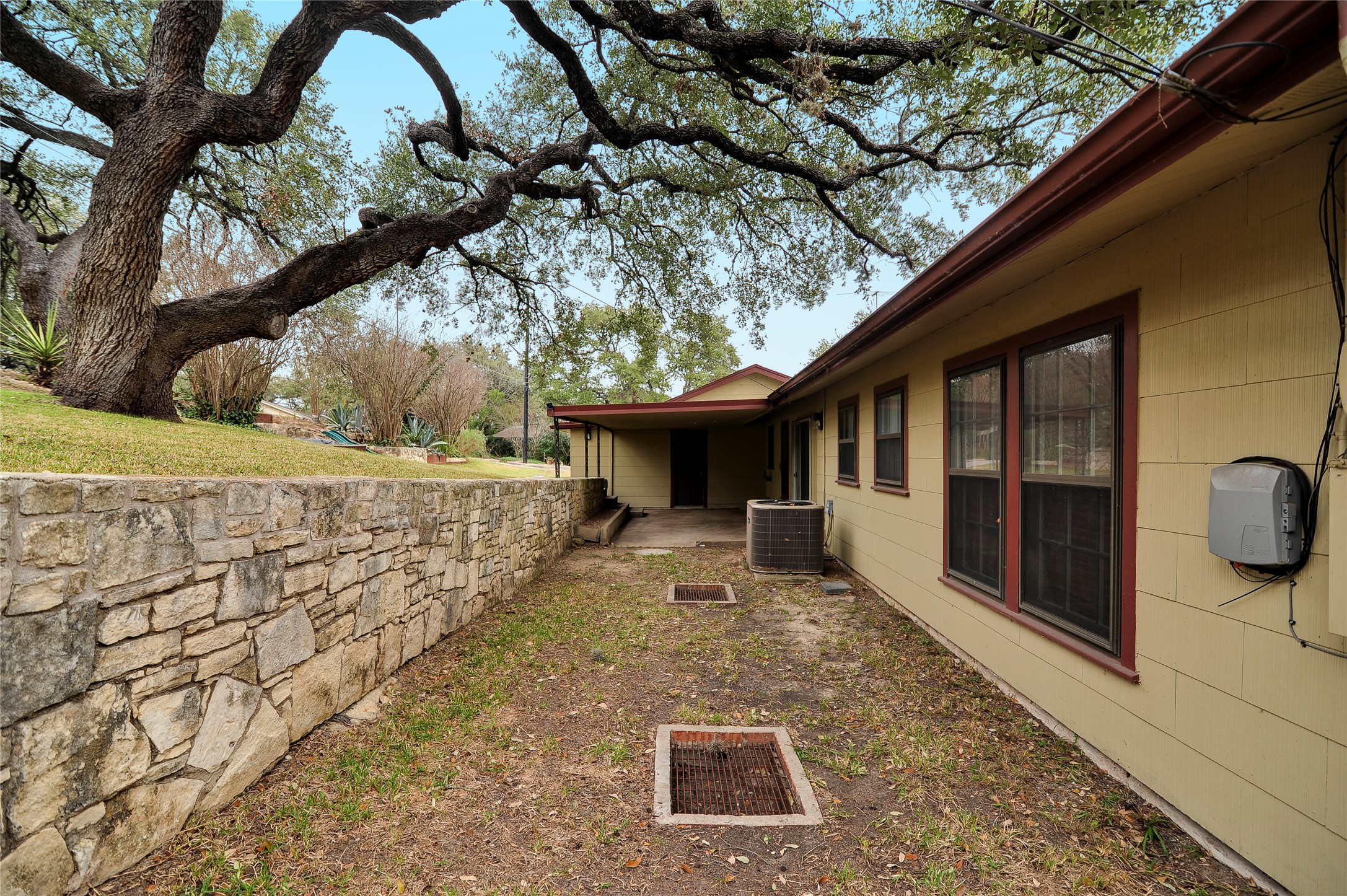 2300 Rebel Road Austin, TX 78704 - Photo 23 of 26 Mature trees shade this charming residence with a stone retaining wall and an inviting covered patio.